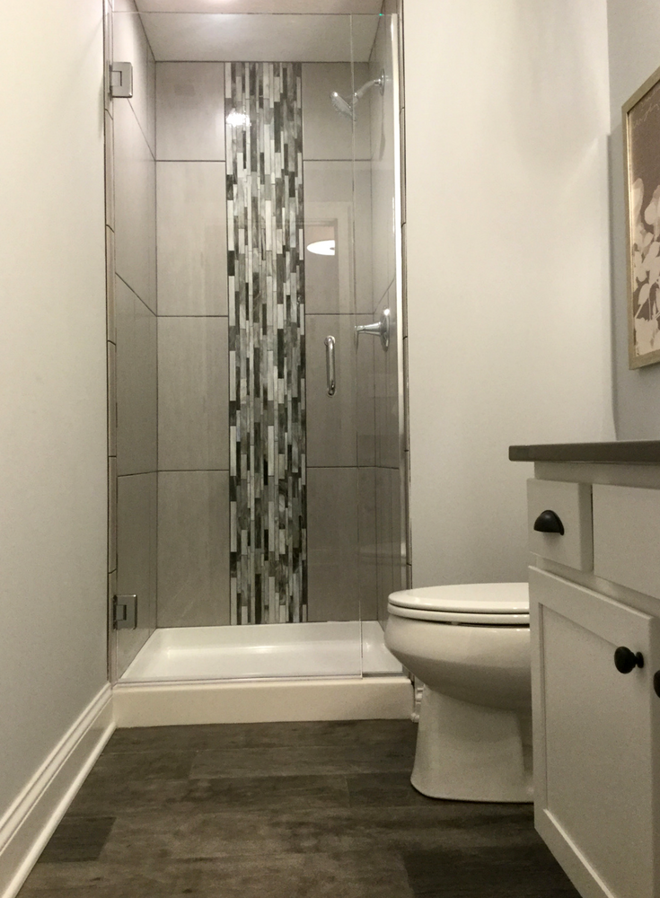 Decorative vertical tile design in a small shower enclosure | Innovate Building Solutions