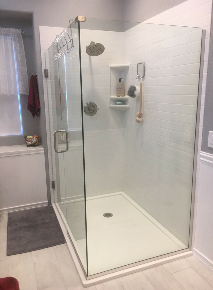 Double curb low profile white solid surface shower pan with a frameless glass | Innovate Building Solutions