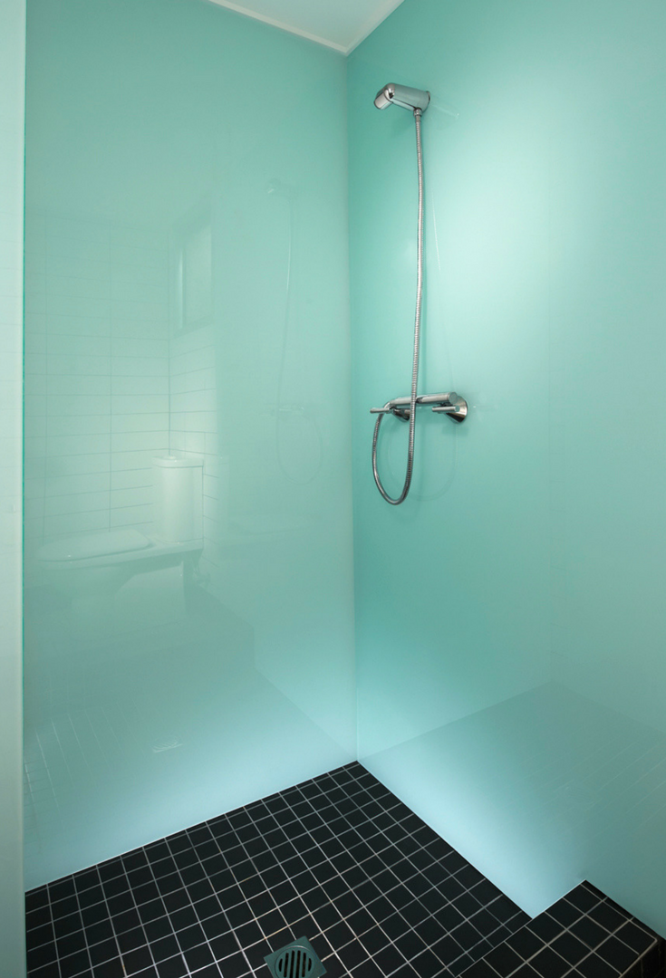 Glacier colored high gloss corner shower wall with black ceramic tile shower floor in an upscale home | Innovate Building Solutions 