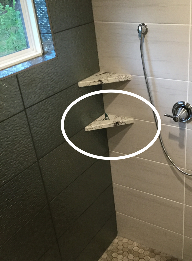 Plastic army man on a custom luxury shower corner shelf | Innovate Building Solutions 