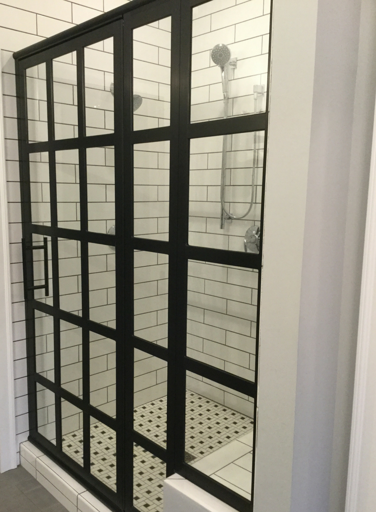 Sliding shower door with black grids in a traditional shower | Innovate Building Solutions