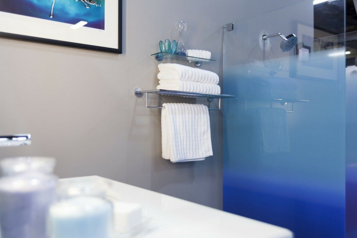 A multi blue colored glass enclosure for a decorative shower stall | Innovate Building Solutions 