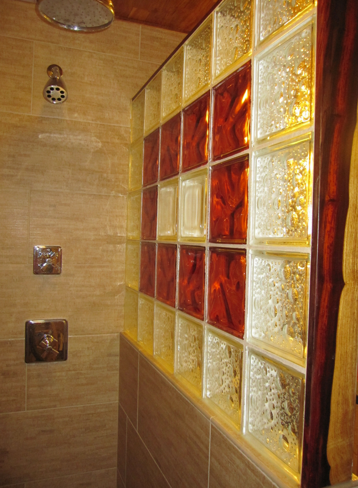 Ruby red glass blocks with a bubble pattern blocks and cocobolo wood shower trim | Innovate Building Solutions 