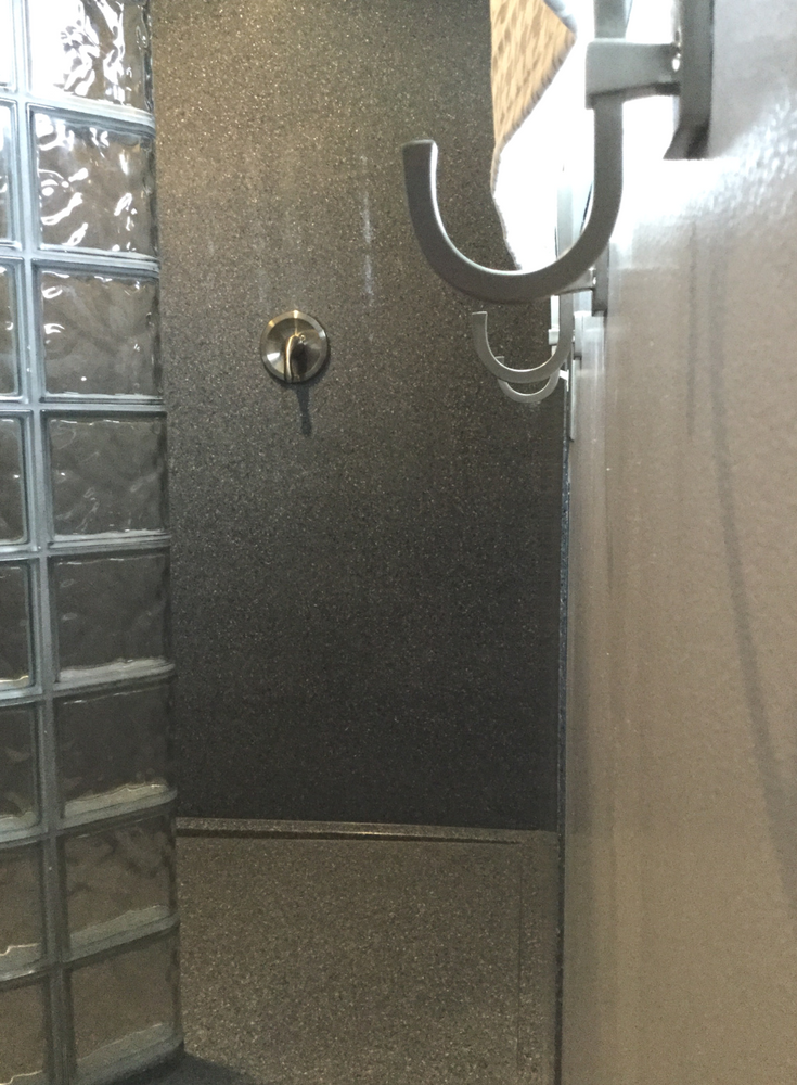 Gray colored solid surface shower wall panels in a curved glass block walk in shower | Innovate Building Solutions 