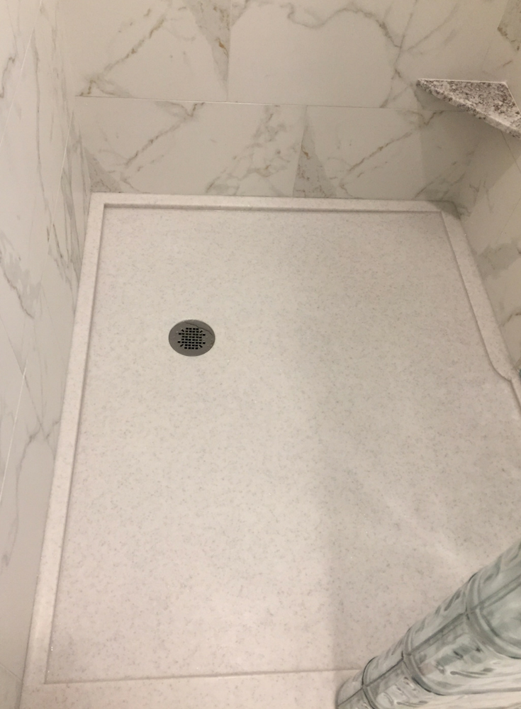 Solid surface shower base with a custom drain location for a glass block walk in shower | Innovate Building Solutions
