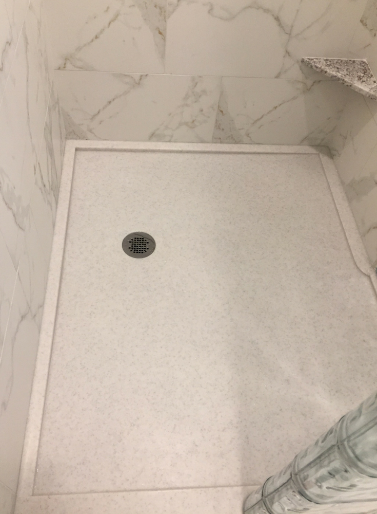 Solid surface shower base with a custom drain location for a glass block walk in shower | Innovate Building Solutions 