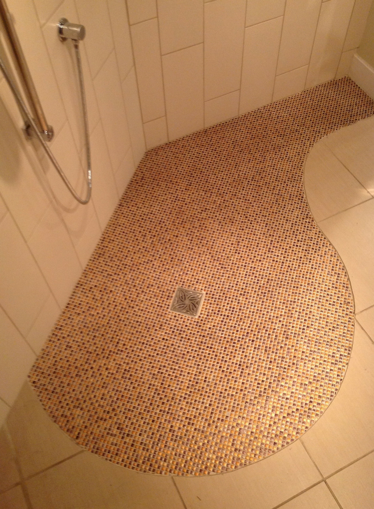 This one level shower floor with a circular mosaic tile pattern is simple to enter and creates a unique style for a person with any level of mobility | Innovate Building Solutions #Shower #BarrierFree #OneLevelShower #Shower 