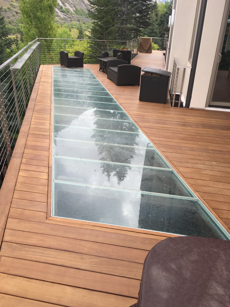 Glass decking to move light to a patio level below | Innovate Building Solutions 