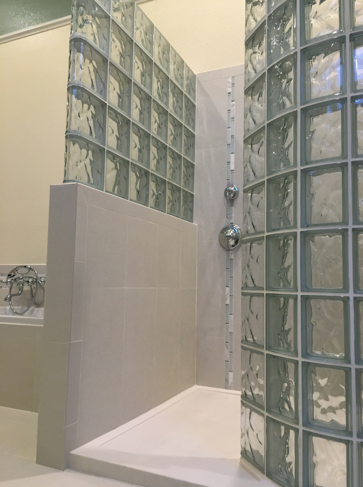 Glass block curved shower on a solid surface shower pan | Innovate Building Solutions | #GlassBlockShower #ShowerDesign #GlassBlockShower