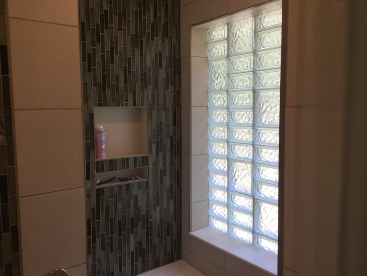 Niche storage around a multi size glass block bathroom window | Innovate Building Solutions | #BathroomStorage #GlassBlock #ShowerDesign