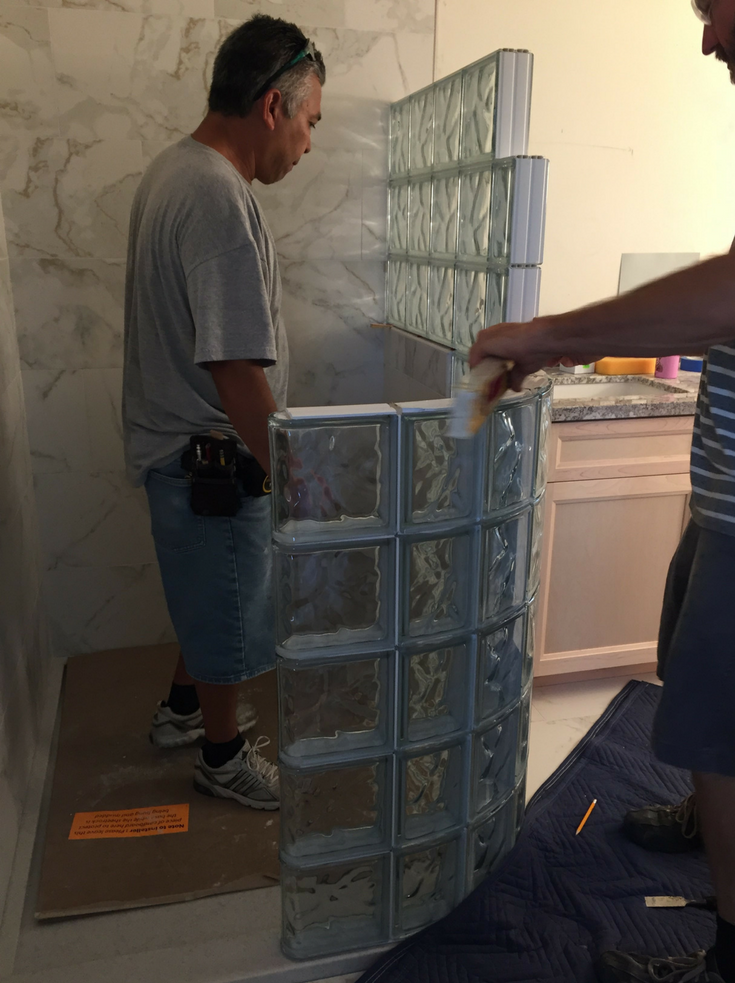 Prefabricated glass block shower wall panels being installed | Innovate Building Solutions | #GlassBlockShower #GlassBlockInstallation #CurvedGlassBlock