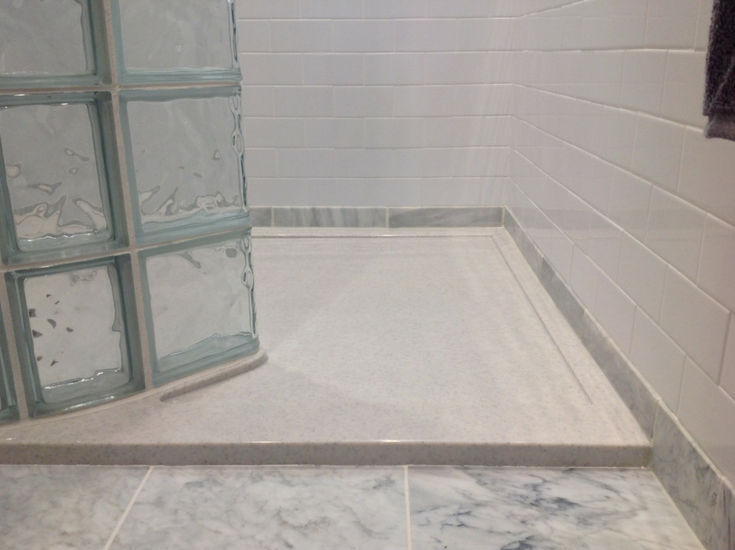 SCultured stone low profile shower pan with a curved glass block wall | Innovate Building Solutions