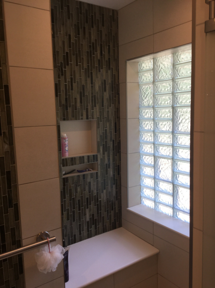 Niche in a shower with a glass block bathroom window with a multi block | Innovate Building Solutions | #GlassBlockWindow #BathroomWindow #NicheBathroom #ShowerStorage