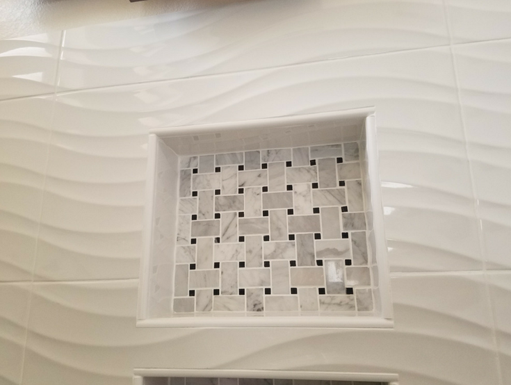 White ceramic wave pattern 3 dimensional tiles in a walk in shower | Innovate Building Solutions | #ShowerPanels #WalkInShower #CeramicTiles