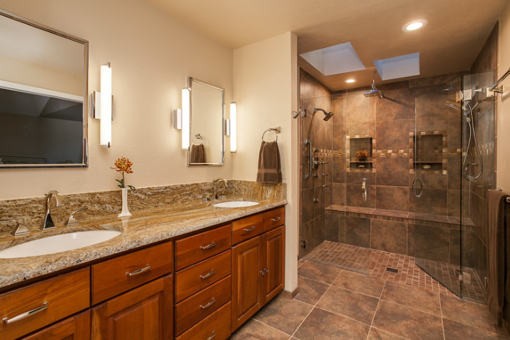 One level wet room with a large pivoting shower door | Innovate Building Solutions | #TiledFloor #OneLeveWetRoom #WetRoom