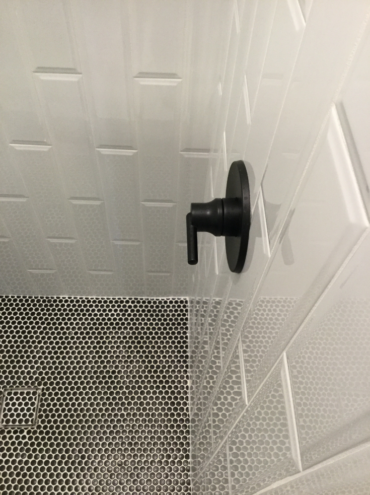 Three dimensional vertical tiles with black faucet fixtures Columbus | Innovate Building Solutions | #TileTexture #SubwayTile #BathroomDesign