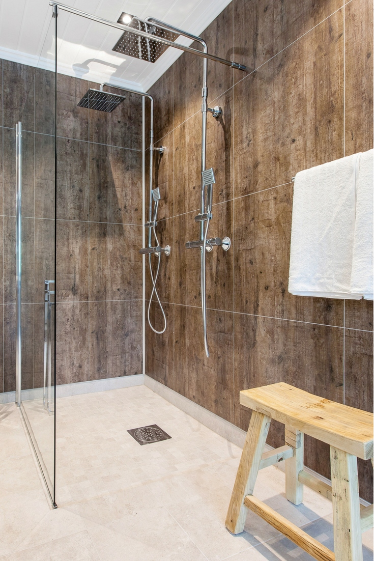 Laminated shower wall panels in a rough wood design | Innovate Building Solutions | #LaminateShowerPanels #WallPanels #BathroomRemodeling