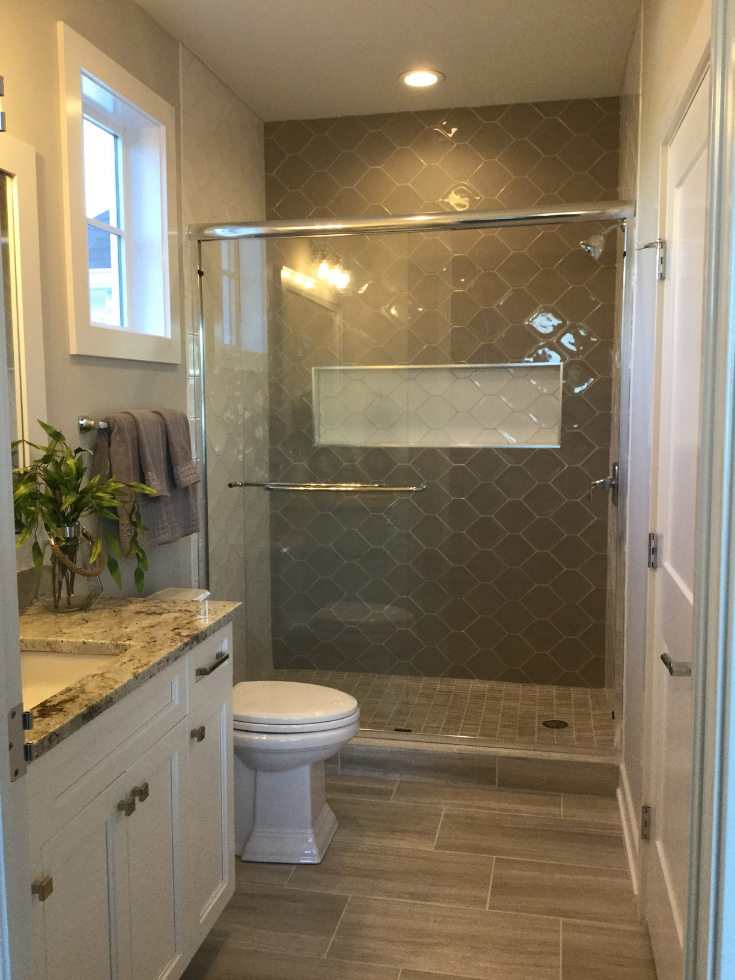 Ceramic tile a fish scale shower design | Innovate Building Solutions | #TiledShower #FishScales #ShowerRemodel #UniqueBathroomDesign