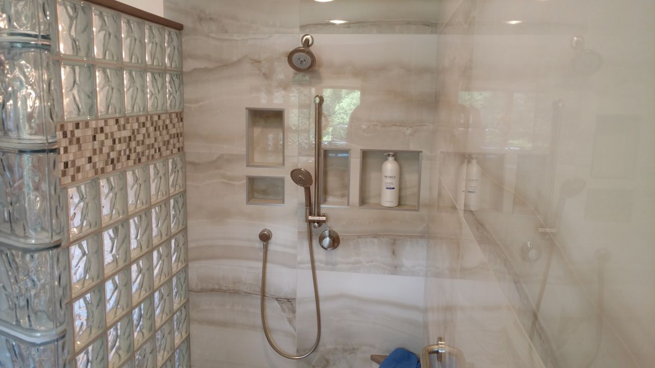 Glass block shower kit with a tile border row | Innovate Building Solutions | #LargeTile #GlassBlockShower #bathroomremodeling