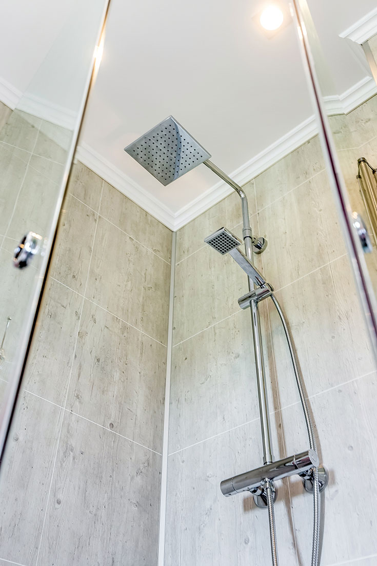 https://blog.innovatebuildingsolutions.com/wp-content/uploads/2019/07/Spa-like-rain-shower-head-with-cracked-cement-laminated-panels.jpg