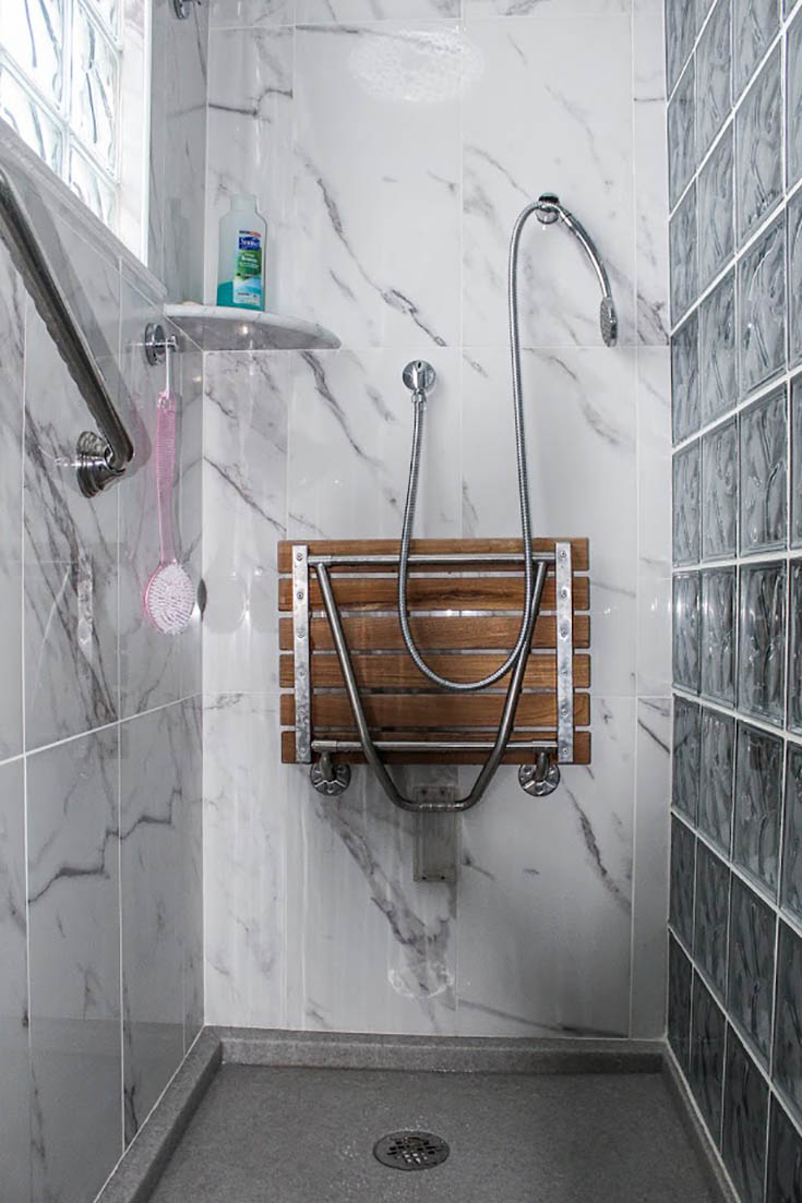 A custom cultured stone shower pan or base | Innovate Building Solutions | #CustomShowerBase #GlassBlockWall #CustomBathroom #BathroomDesign 