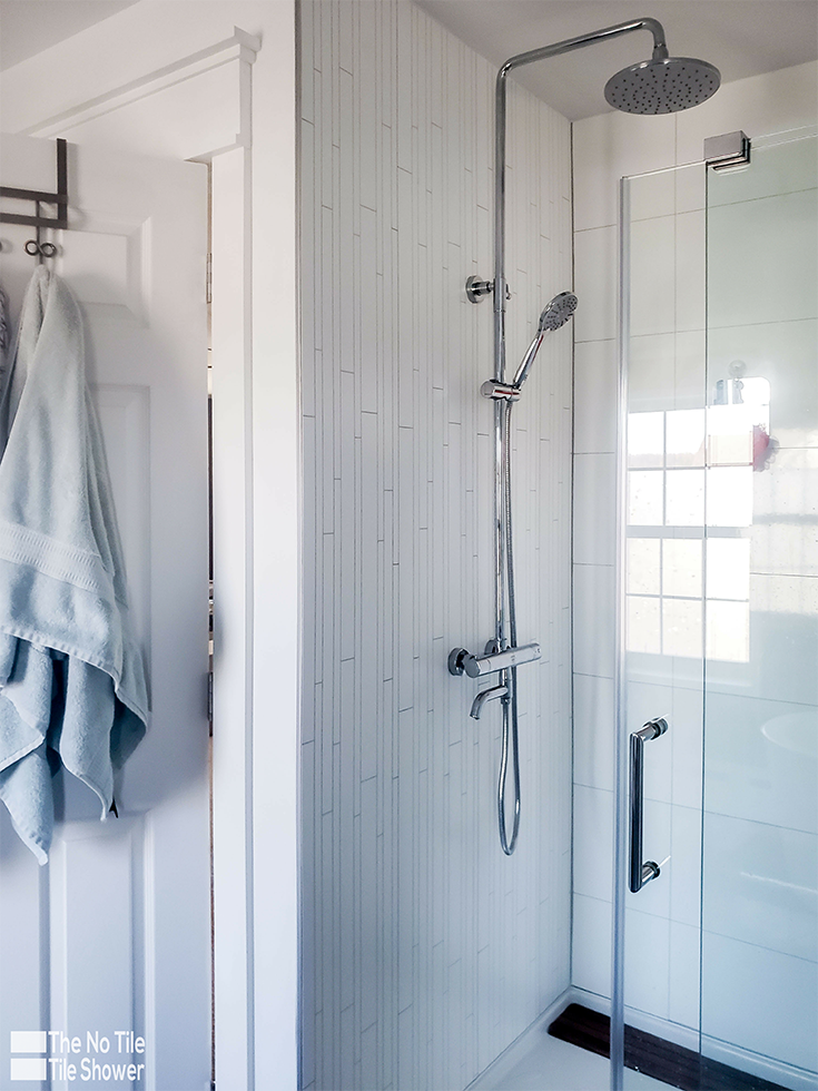 A rain head in with laminated DIY shower wall panels | Innovate Building Solutions | #LaminatePanels #DIYShowerRemodel #ShowerInstall #ShowerHead