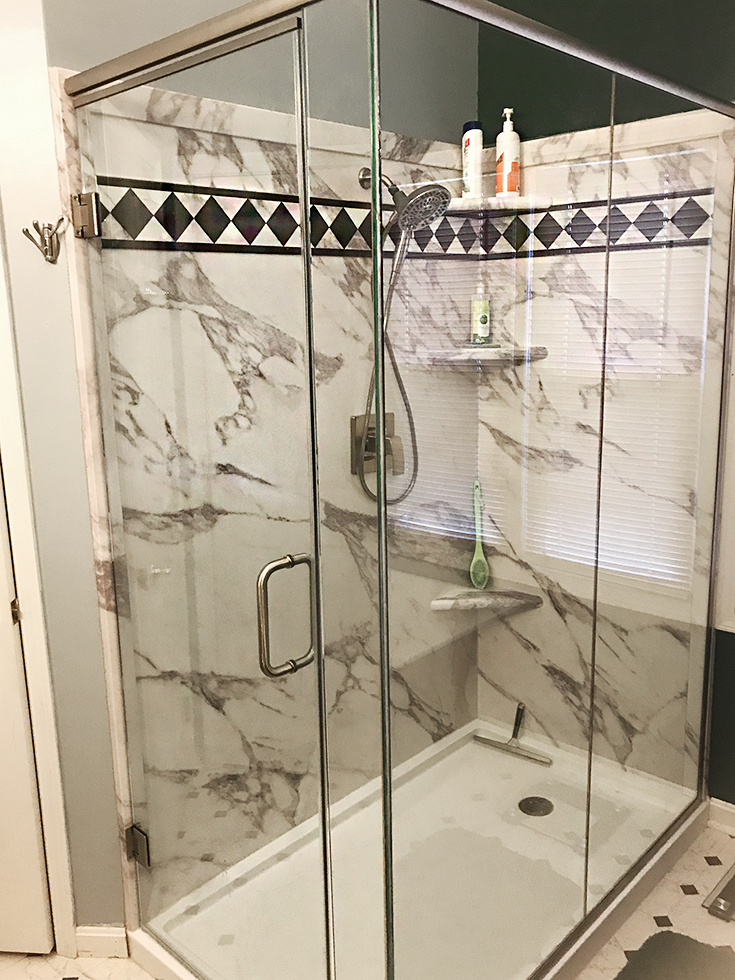 PVC composite shower panels in a calcutta white pattern | Innovate Building Solutions | #PVCShower #ShowerPan #BathroomRemodel