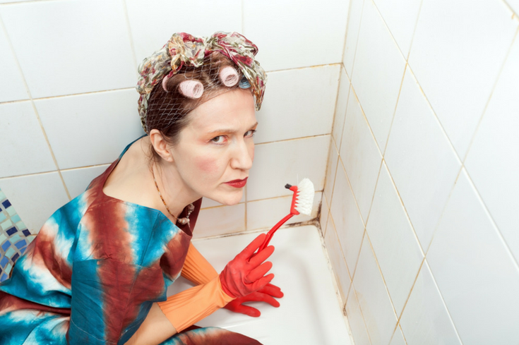 Woman cleaning tile grout in opening | Innovate Building Solutions | #CleanGrout #WallPanels #Moldygrout 