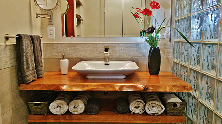 live edge bathroom vanity top by a glass block shower wall | Innovate Building Solutions | #bathroomvanity #VanityTop #BathroomRemodel