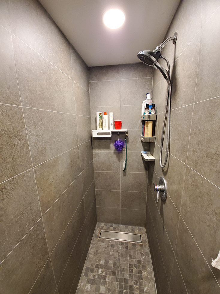 Shower wall panels with shelves and storage mounted onto the wall | Innovate Building Solutions | #ShowerSystem #Laminatewallpanels #Tileshower