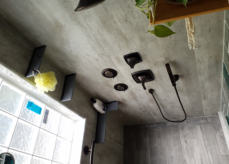 floating shower shelves installed on cracked cement laminate wall panels | Innovate Building Solutions | #Laminatewallpanels #FloatingShelf #CornerShelves