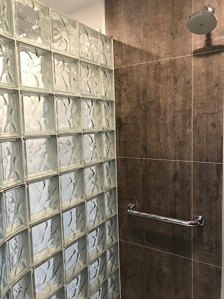 rough wood manly laminate grout free shower wall panel system glass block wall | Innovate Building Solutions | #WallPanels #ShowerWallPanels #LaminateWallPanel #RoughWood