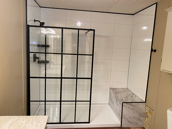 Question 7 matte black fixed shower door with white marble laminate shower panels and a bench seat | Innovate Building Solutions #showerdoor #laminatewallpanels #Whiteshower