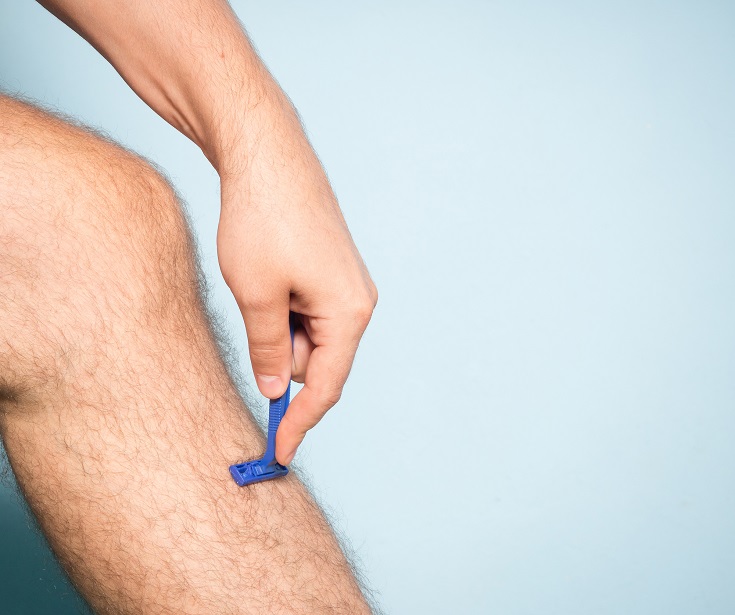 Caucasian man shaving hair from legs | Innovate Building Solutions #ShowerAccessories #ShowerRemodel #BathroomRemodel