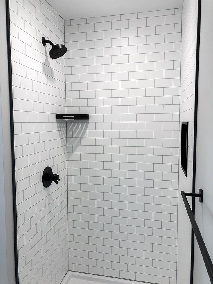Section 2 example 5 white subway tile fibo wall panels black trim niche | Innovate Building Solutions | bathroom remodeling | Cleveland Design Ideas | Subway tile shower display
