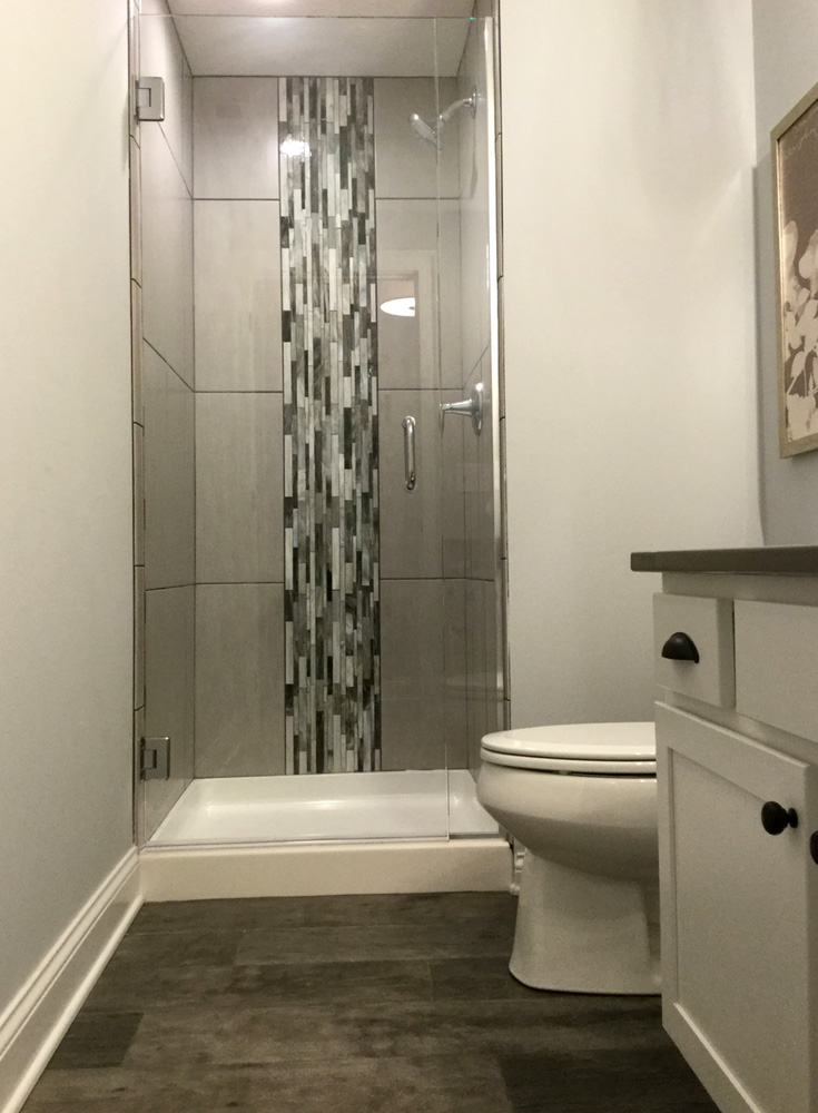 Out example 7 small tile shower vertical accent with a pivoting thick glass door - Innovate Building Solutions, Cleveland Ohio Small Showers, Custom Bathroom Shower, Small Space Bathroom Project, Glass Shower Doors